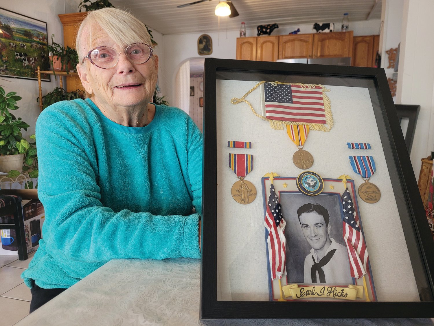 FIRST HUSBAND: Sally displays her late husband Earl Hicks’ Navy photo with several of the medals he earned while fighting in the Pacific theater during World War II. Earl died in 1995.